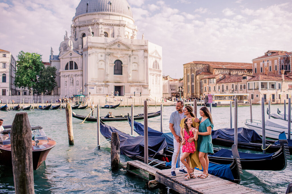 A joyful family photo taken in Venice with the Basilica of Santa Maria della Salute in the background—hire a Venice photographer to capture your cherished moments.